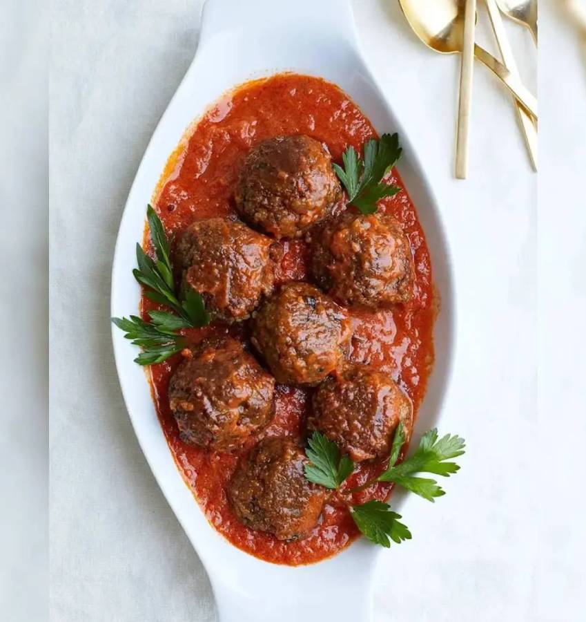 Meatballs in tomato sauce with parsley.